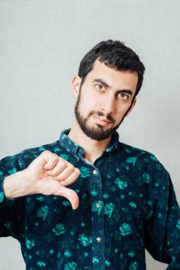 Sakallı genç adam baş parmak işareti gösteriyor.