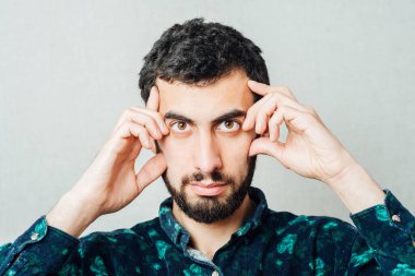 Adam, baş ağrısı ya da migrenden dolayı acı içinde ağlarken ve yüzünü buruştururken alnını ovuşturuyor.