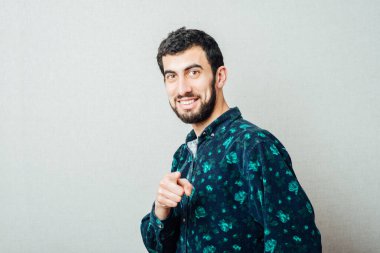 Sıradan bir genç adam kamerayı işaret ediyor ve elinde bir işaret var. 