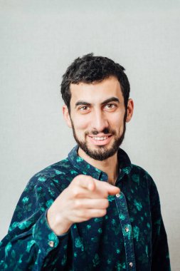 Sıradan bir genç adam kamerayı işaret ediyor ve elinde bir işaret var. 