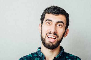 Sakallı adam gülümsüyor.