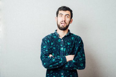 Düz bakan bir adamın portresi, elleri göğsünde katlanmış.