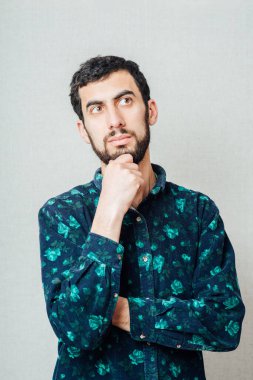 Düz bakan bir adamın portresi, elleri göğsünde katlanmış.