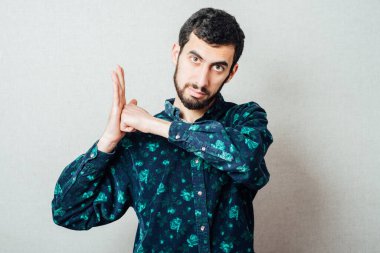 Avucunda yumruğu olan sakallı adam.