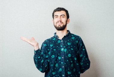 Genç çekici iş adamı avucunun üzerinde boş fotokopi alanı gösteriyor. Müşterinin ürün ya da metin eklemesi için. Mutlu ve heyecanlı görünüyor.