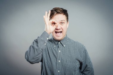 Elleri gözlerinin üzerinde, parmaklarından bakan bir adam.