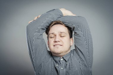 Elleri başının arkasında rahat genç bir adam.