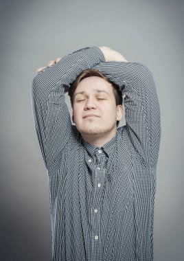 Elleri başının arkasında rahat genç bir adam.