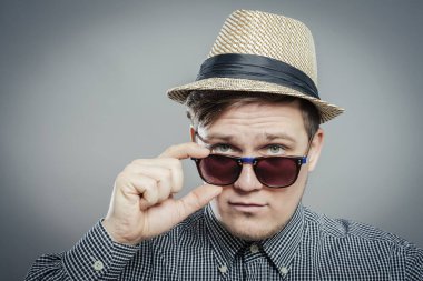 Kendine güveni tam bir adam. Koyu gözlüklerini çıkarıyor ve sana bakıyor..