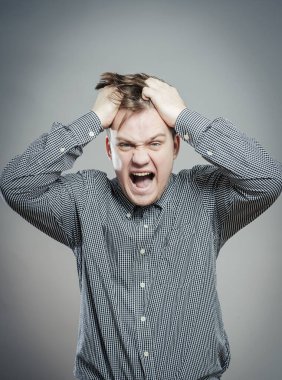 Öfkeli genç adamlar ellerini tutup çığlık atıyorlar.