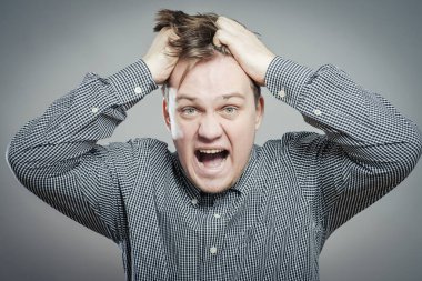 Öfkeli genç adamlar ellerini tutup çığlık atıyorlar.