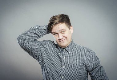 Kafası karışmış, eli saçında bir erkek portresi.