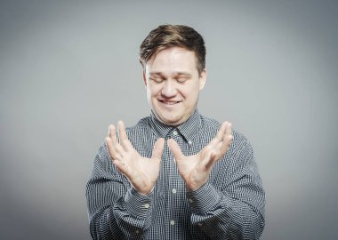 Şok olmuş ve şaşırmış görünen genç adam elleri havada.