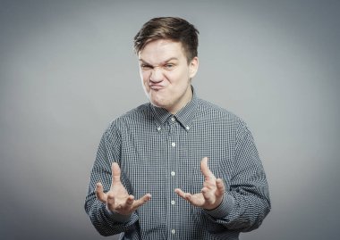 Şok olmuş ve şaşırmış görünen genç adam elleri havada.