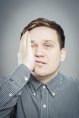 Gri arkaplanda sıkılmış bir adam