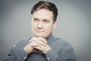 # Adam mutlu görünüyor elleri ağıza yakın katlanmış #