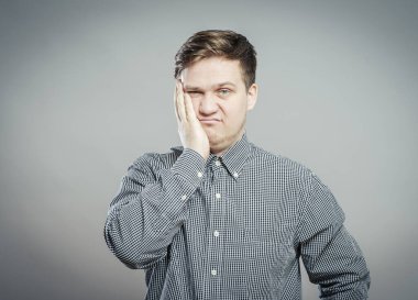 Gri arkaplanda sıkılmış bir adam