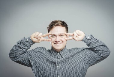 Zafer ya da barış işareti gösteren genç adam