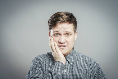 Genç bir adam diş ağrısı hisseder.