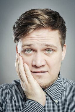 Genç bir adam diş ağrısı hisseder.