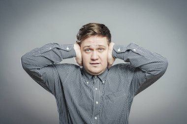 Genç adam duymak istemediği şeyleri gösteriyor. Parmakları kulaklarında