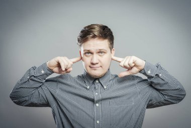 Genç adam duymak istemediği şeyleri gösteriyor. Parmakları kulaklarında