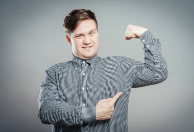 Genç adam kaslarını gösteriyor.