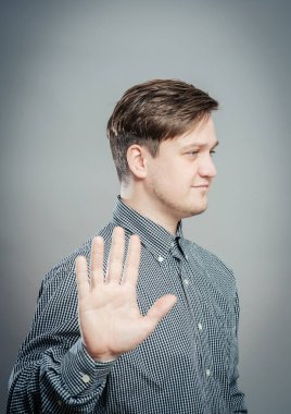 Genç bir adam elleriyle durduruyor.