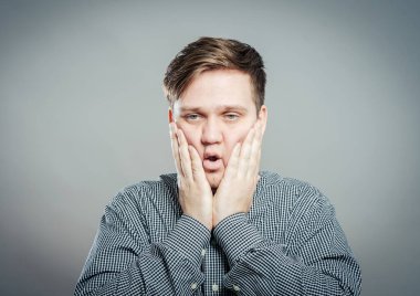 Elleri yüzü asık genç bir adam.