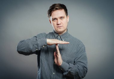 Zaman aşımı işareti yapan genç bir adamın portresi