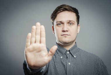 Genç bir adam elleriyle durduruyor.