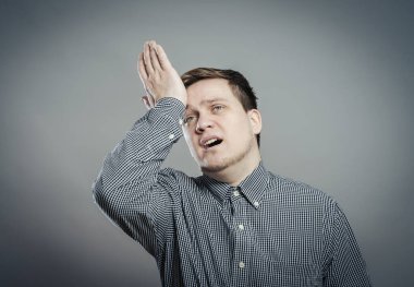 Üzgün adam, alnını eliyle tutuyor.