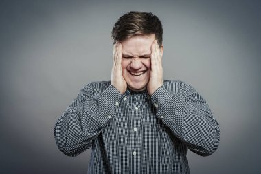 Baş ağrısı çeken genç bir adam.