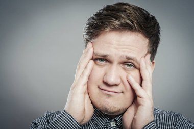 Baş ağrısı çeken genç bir adam.