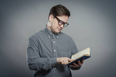 Gri arka planda izole edilmiş gözlüklü genç adam portresi.