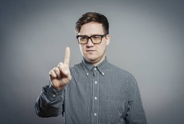 Genç bir adam parmağına bakar.