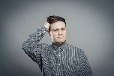 Kafası karışmış, eli saçında bir erkek portresi.