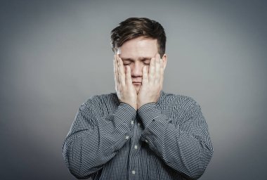 Elleri yüzü asık genç bir adam.