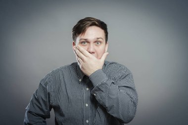 Duyarlı bir adam elleriyle ağzını kapalı tutar.