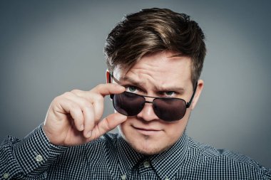 Gözlüklü genç çekici adamın stüdyo fotoğrafı.