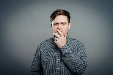 Burnunu kötü kokuya karşı tutan bir adam.