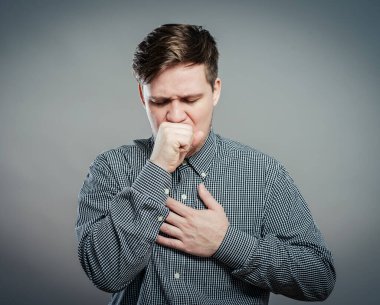 Genç adam hasta ve ilaç alıyor.