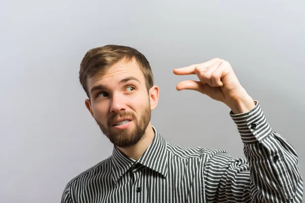 Joven Guapo Muestra Poco Gesto Sobre Fondo Gris — Foto de Stock