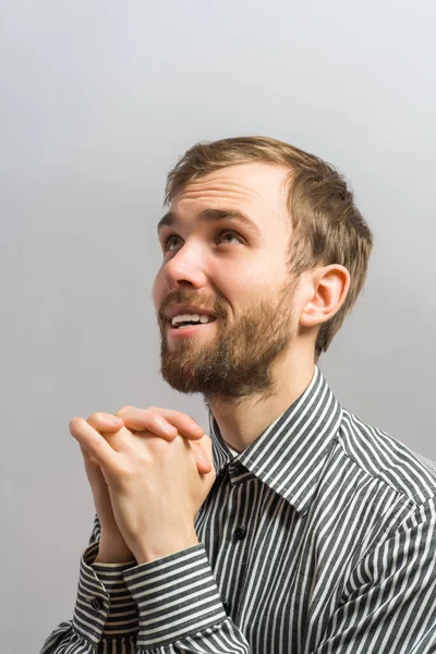 若いハンサムな男があなたの口の近くで手を祈る ジェスチャー 灰色の背景で — ストック写真