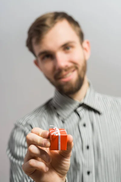 Homem Segurando Pequeno Presente Vermelho Sua Mão Direita Olhando Para — Fotografia de Stock