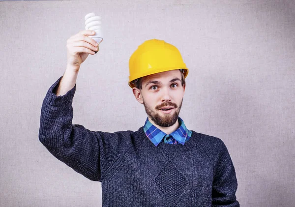 Mladý Stavitel Drží Energeticky Úspornou Žárovku — Stock fotografie