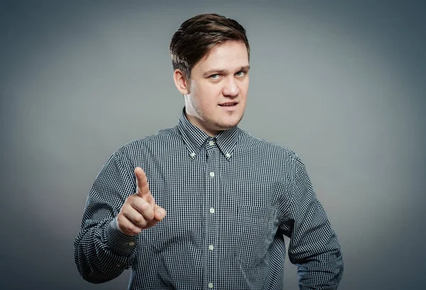 Genç adam, parmağıyla birini işaret ediyor.