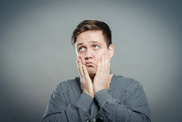 Genç bir adam elleriyle yüzünü yere sürükler.