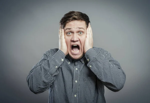 Öfkeli genç adamlar ellerini tutup çığlık atıyorlar.