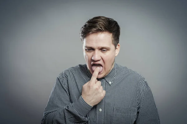 Parmağını ağzına sokmuş genç adam.